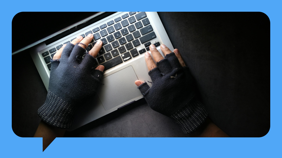 hands with gloves typing on laptop
